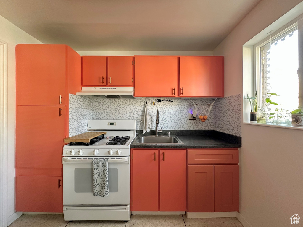 Kitchen featuring tasteful backsplash, sink, and white gas stove