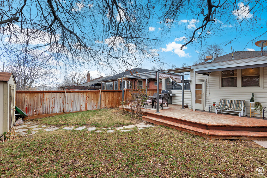 View of yard featuring a wooden deck and a pergola