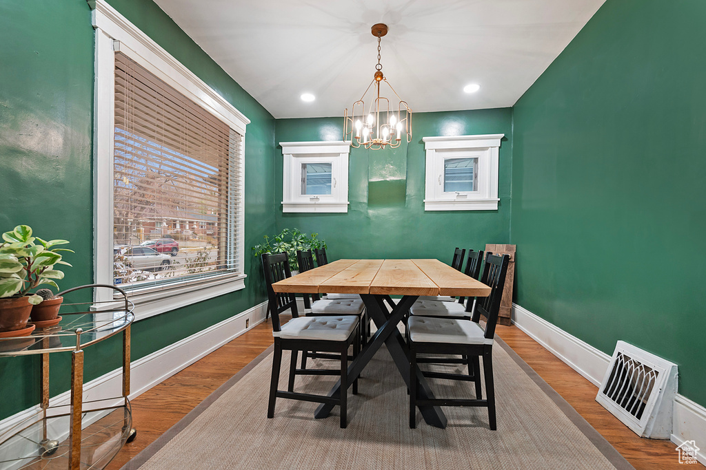 Dining space featuring a notable chandelier and wood-type flooring