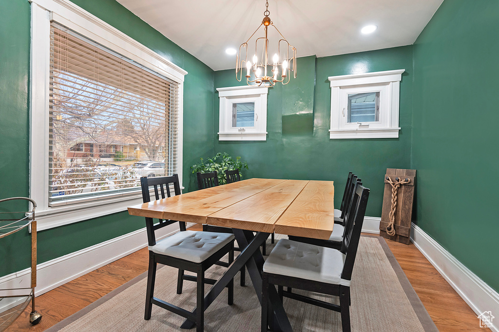 Dining space with a notable chandelier and wood-type flooring