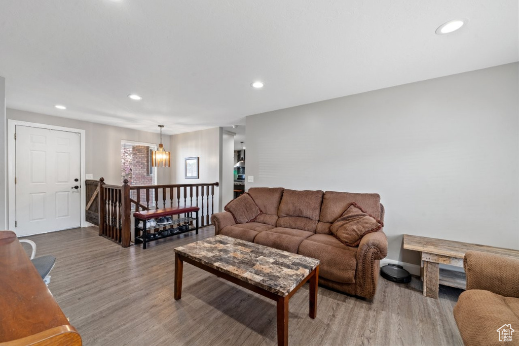Living room featuring recessed lighting, a notable chandelier, and wood finished floors
