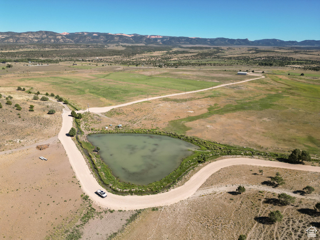 Drone / aerial view with a water and mountain view and a rural view