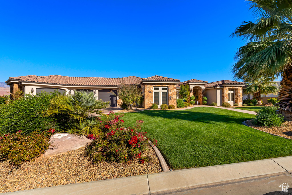 Mediterranean / spanish home featuring a front lawn