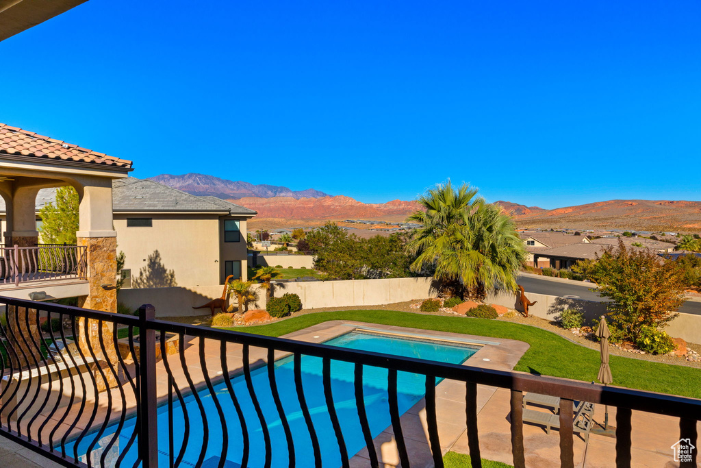 View of swimming pool with a patio and a mountain view