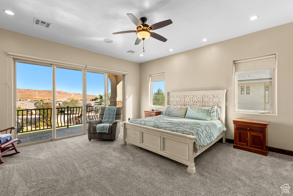 Carpeted bedroom with ceiling fan, a mountain view, a textured ceiling, and access to outside