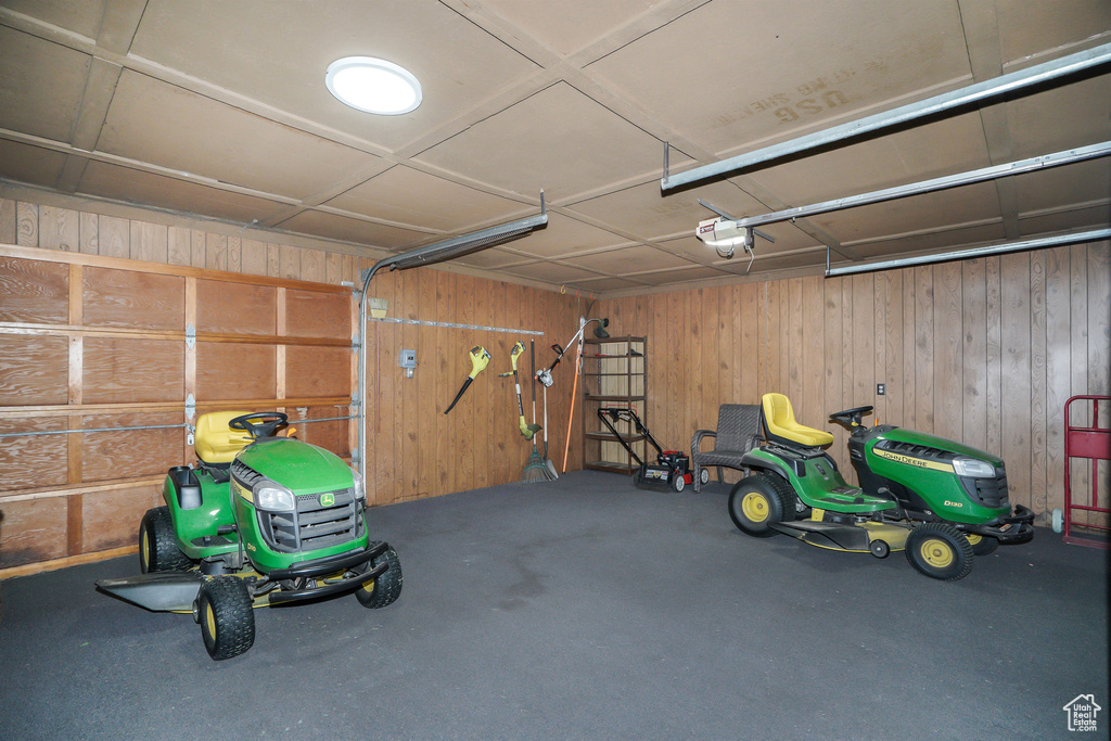 Garage featuring a garage door opener and wood walls