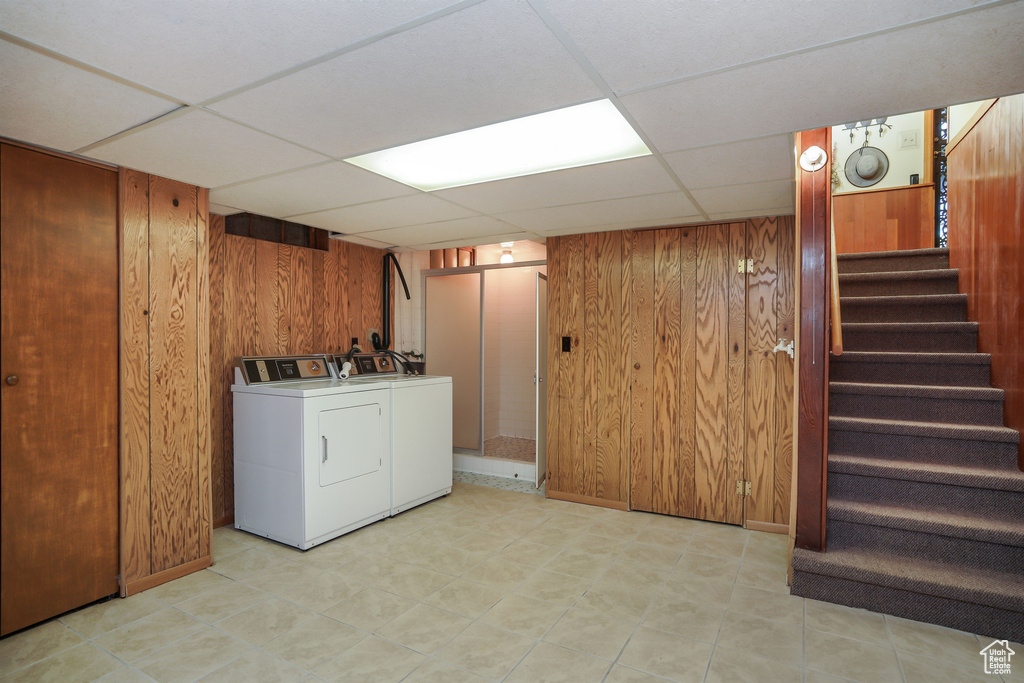 Laundry room with wooden walls and separate washer and dryer