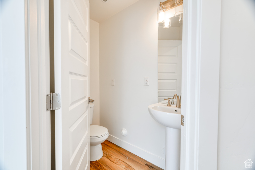 Bathroom featuring sink, hardwood / wood-style floors, and toilet