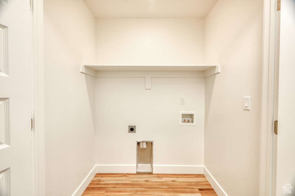 Laundry room with hookup for a washing machine, electric dryer hookup, and light hardwood / wood-style floors