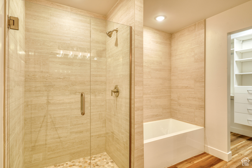 Bathroom featuring wood-type flooring and separate shower and tub