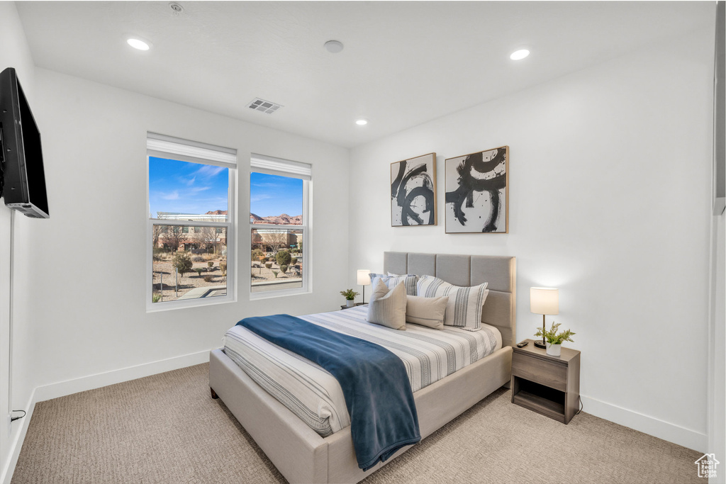 Bedroom with light colored carpet and recessed lighting