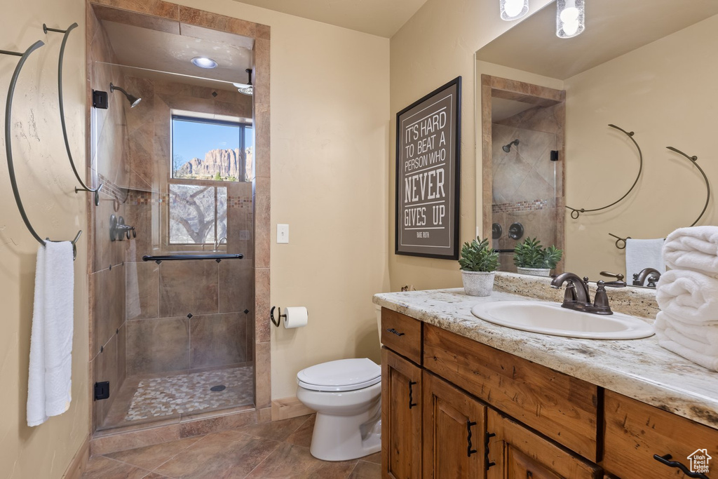 Full bathroom with a shower stall, toilet, vanity, and baseboards