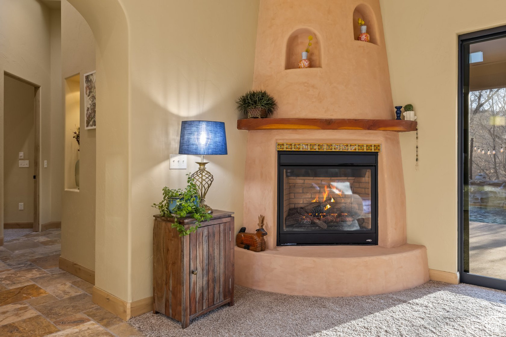 Detailed view of a multi sided fireplace, baseboards, and arched walkways