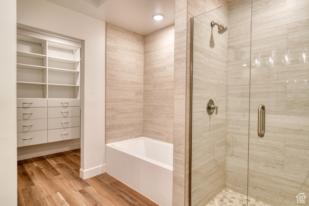 Bathroom featuring hardwood / wood-style flooring and separate shower and tub