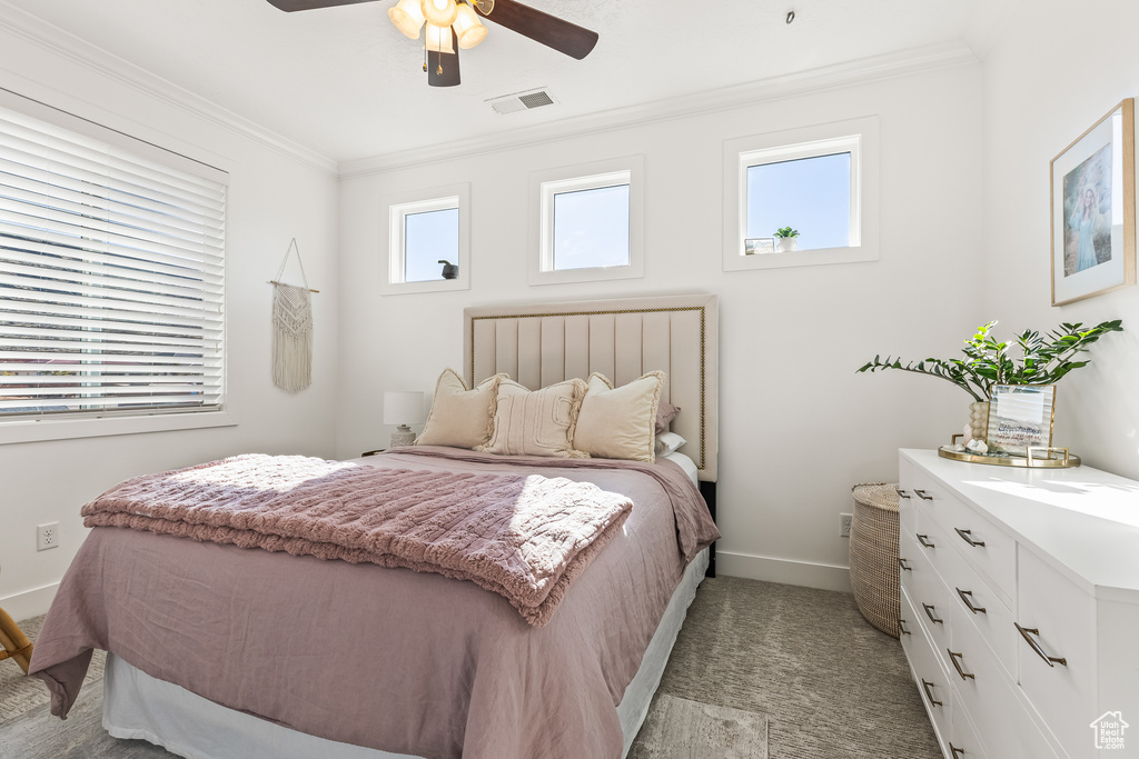 Bedroom with crown molding, light colored carpet, and ceiling fan