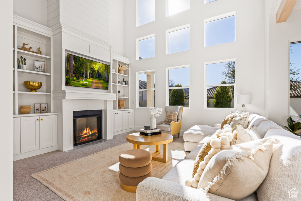 Carpeted living room with a towering ceiling