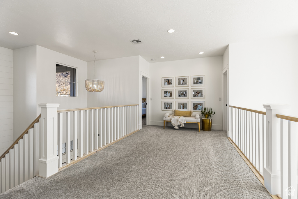 Sitting room featuring carpet flooring and a notable chandelier