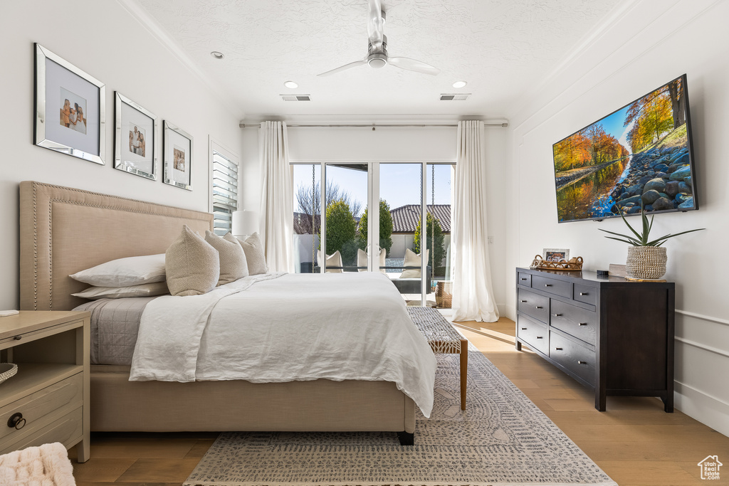 Bedroom featuring ceiling fan, a textured ceiling, access to exterior, and light hardwood / wood-style floors