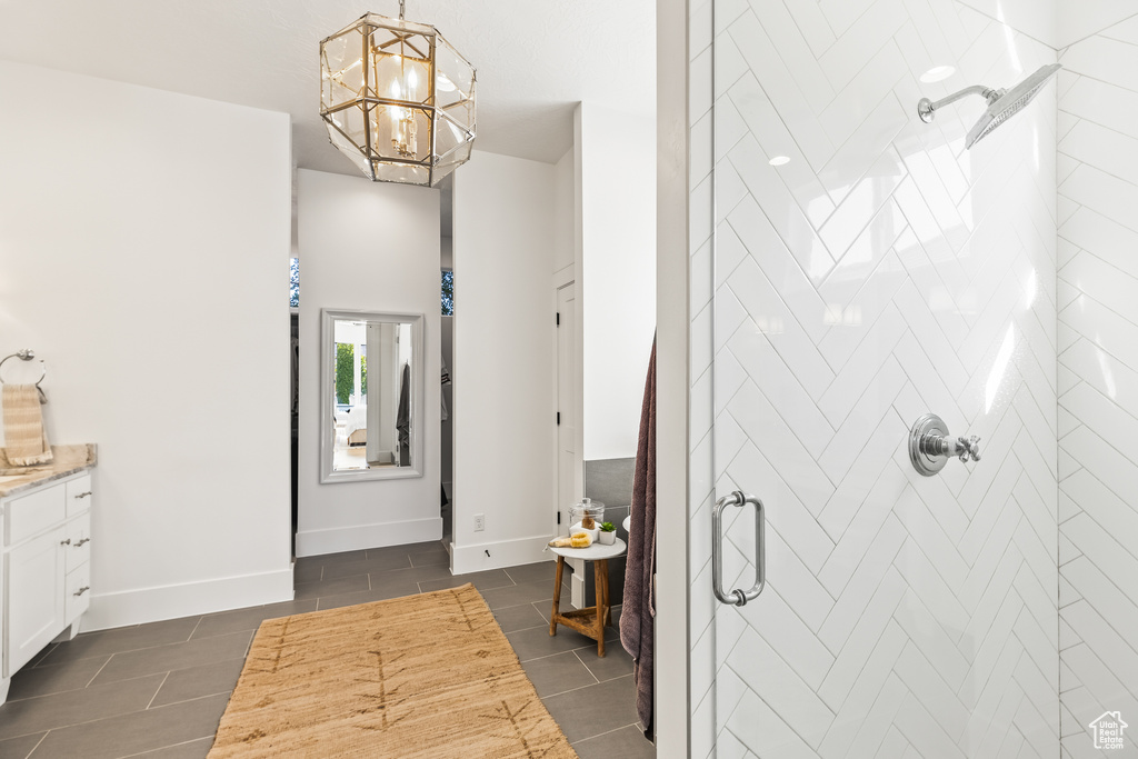 Interior space featuring vanity, an inviting chandelier, and walk in shower