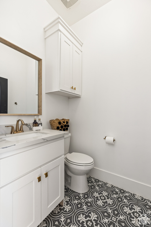 Bathroom featuring tile patterned floors, toilet, and vanity