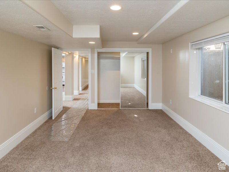 Unfurnished bedroom featuring a closet, carpet, and a textured ceiling