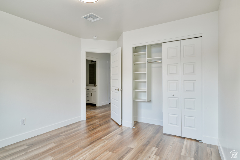 Unfurnished bedroom with a closet and light hardwood / wood-style flooring