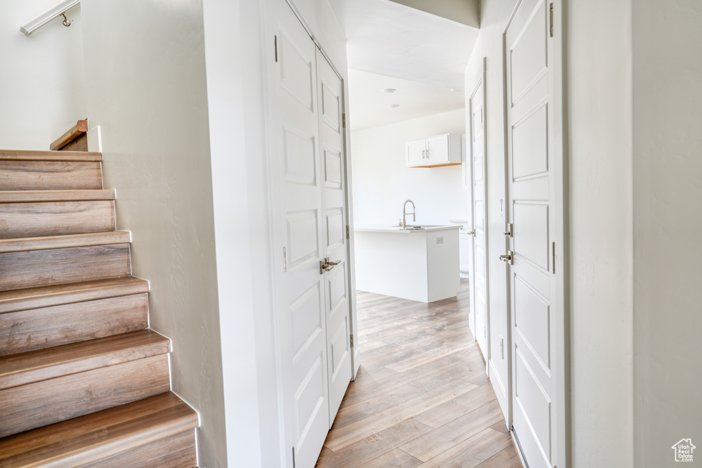 Staircase with hardwood / wood-style flooring and sink