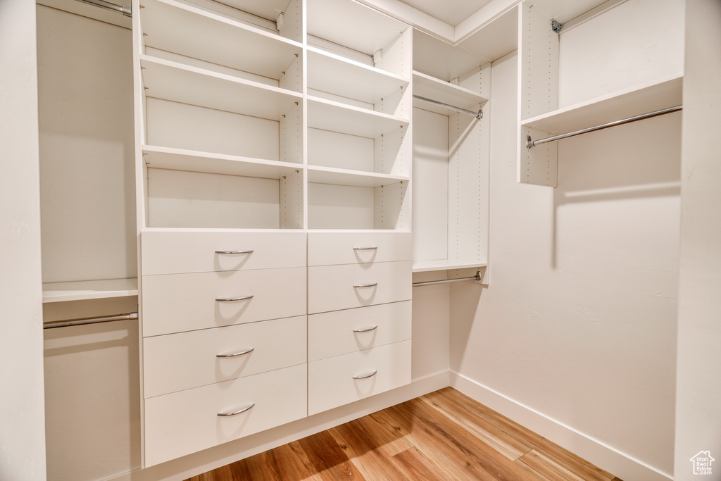 Spacious closet with light hardwood / wood-style floors