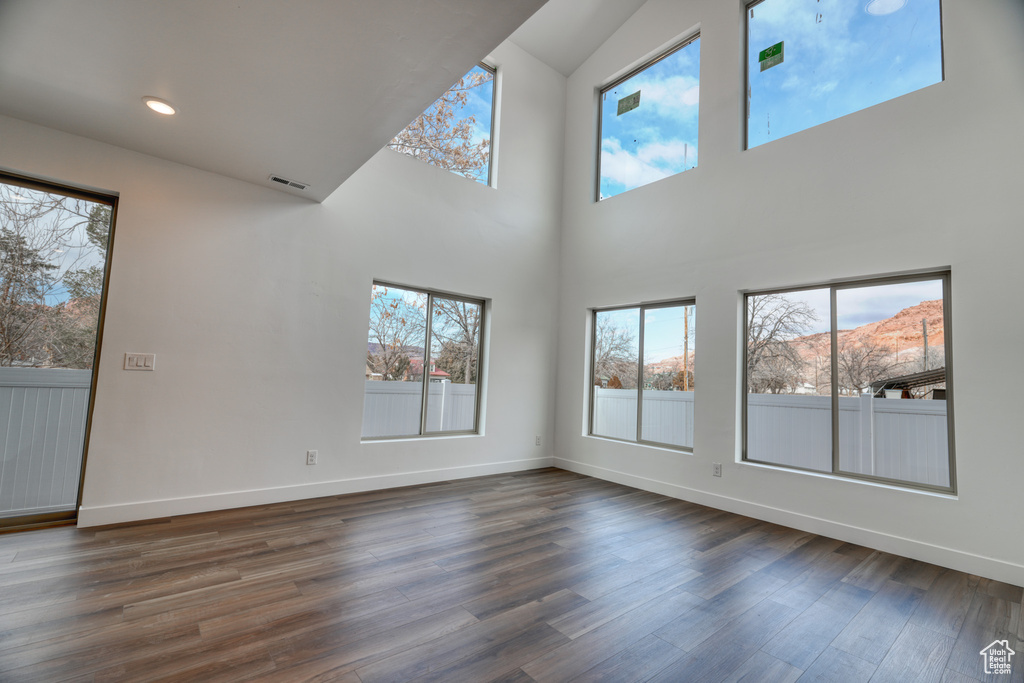 Unfurnished living room featuring dark hardwood / wood-style flooring and a mountain view