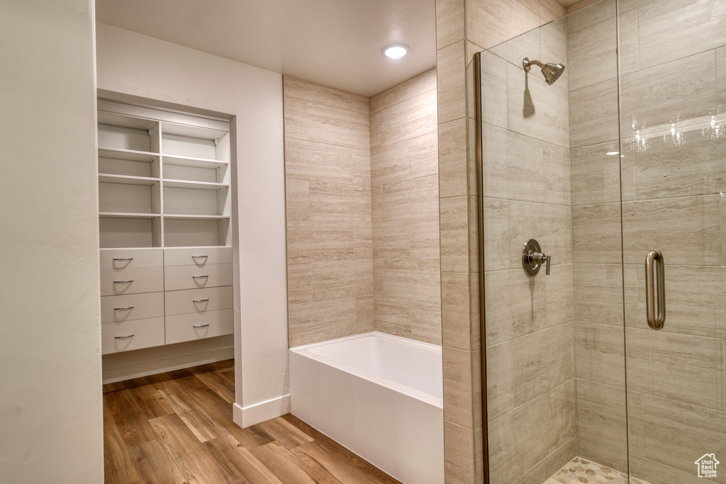 Bathroom with wood-type flooring and independent shower and bath