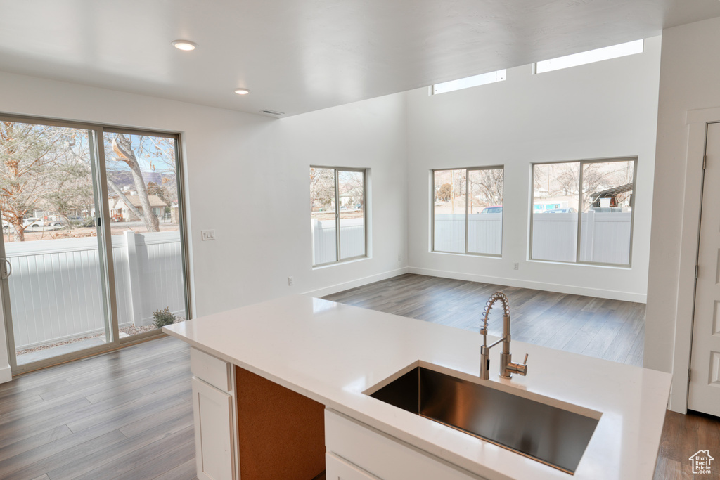 Kitchen with plenty of natural light, sink, white cabinets, and light hardwood / wood-style floors