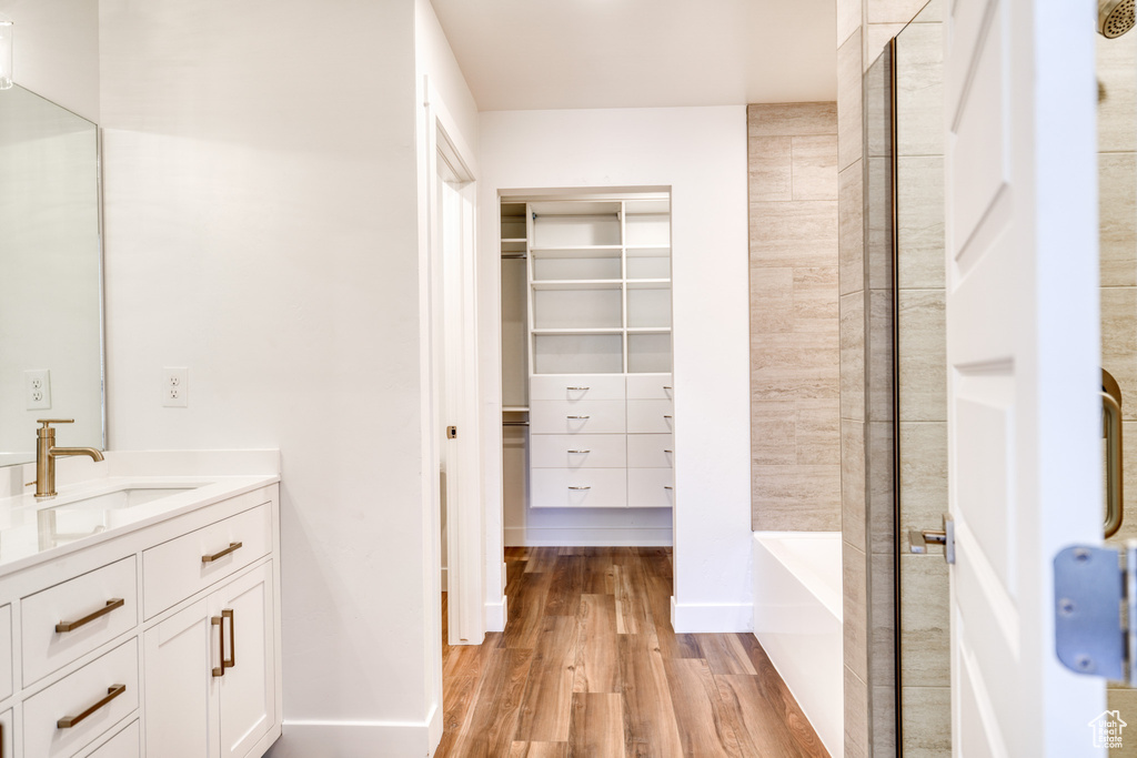 Bathroom featuring vanity, hardwood / wood-style flooring, and separate shower and tub