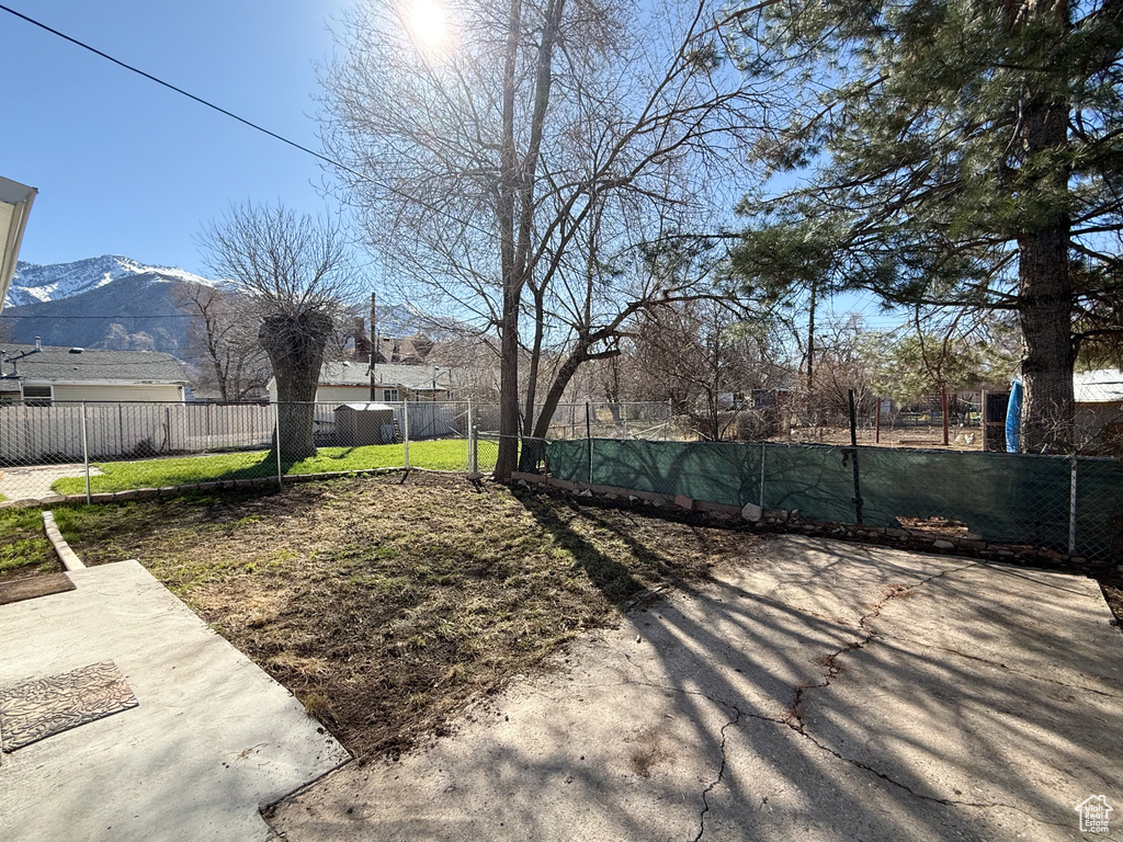 View of yard featuring a patio area, a mountain view, and fence private yard