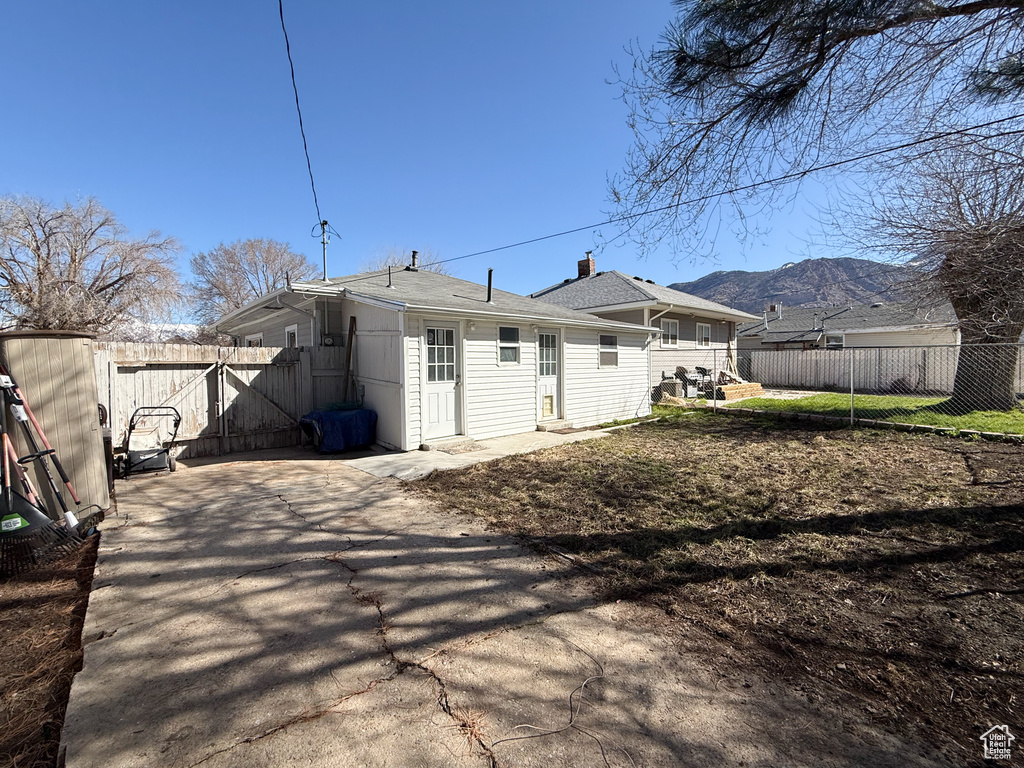 Rear view of house with a fenced backyard and a shingled roof