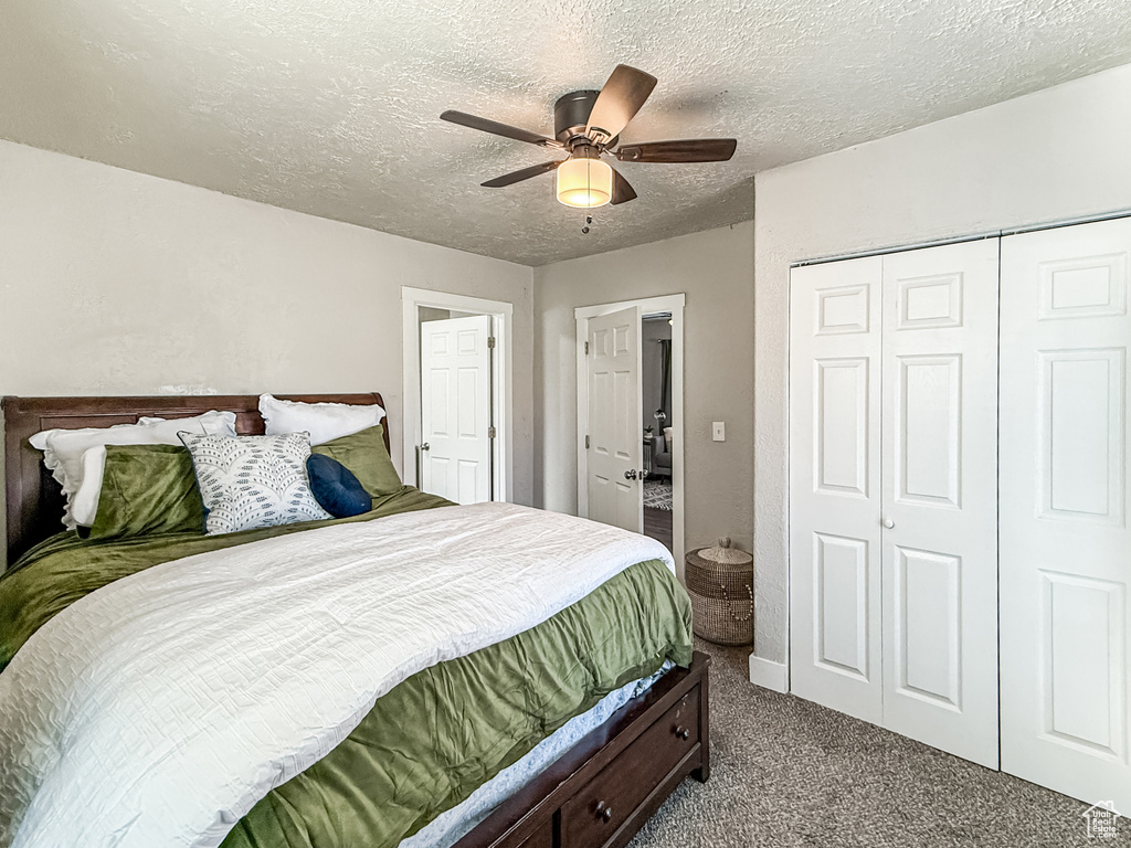 Bedroom featuring a closet, carpet floors, a textured ceiling, and ceiling fan