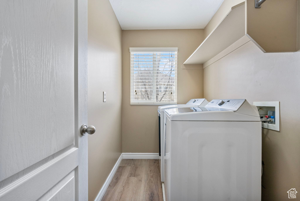 Laundry room featuring separate washer and dryer and light wood-type flooring