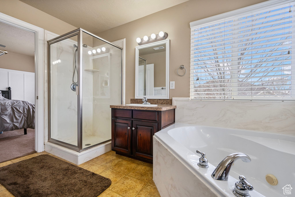 Bathroom with plus walk in shower, vanity, and tile patterned floors