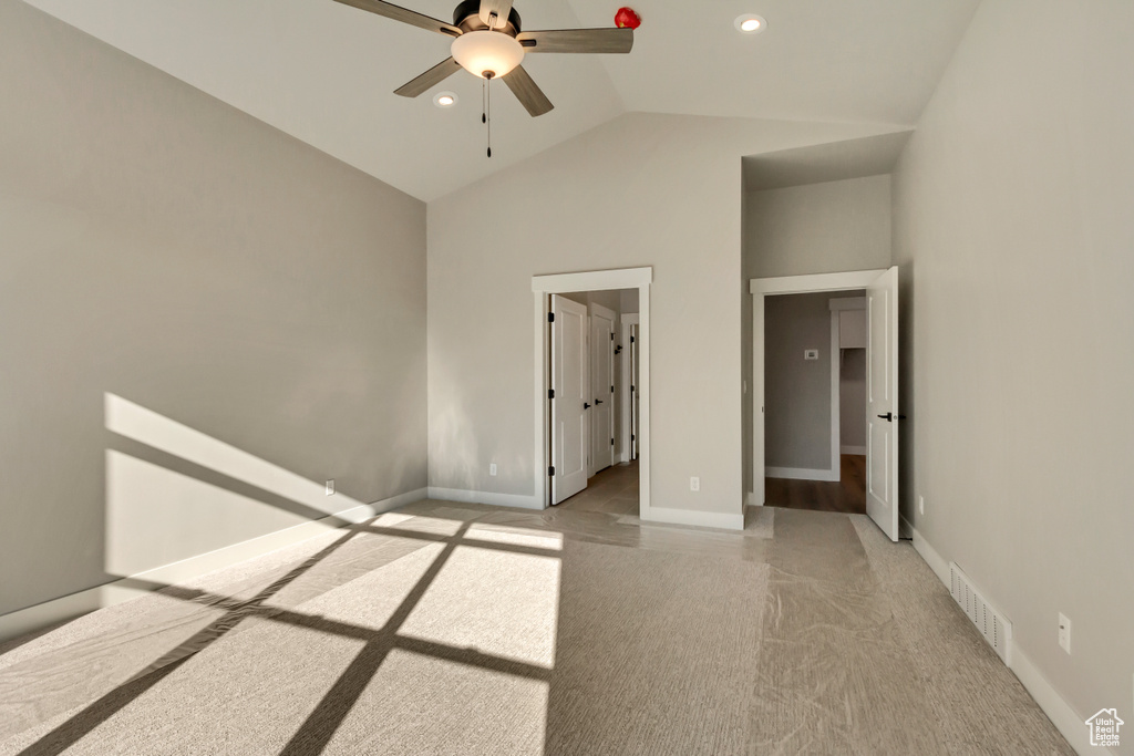 Unfurnished bedroom with high vaulted ceiling and ceiling fan