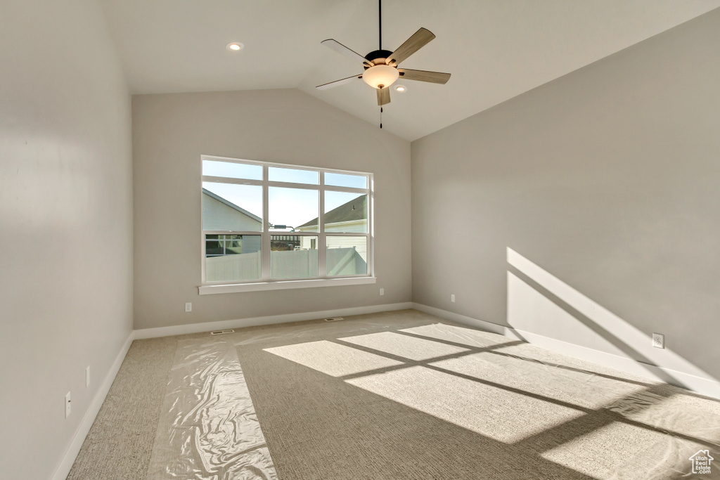 Spare room with vaulted ceiling, light colored carpet, and ceiling fan