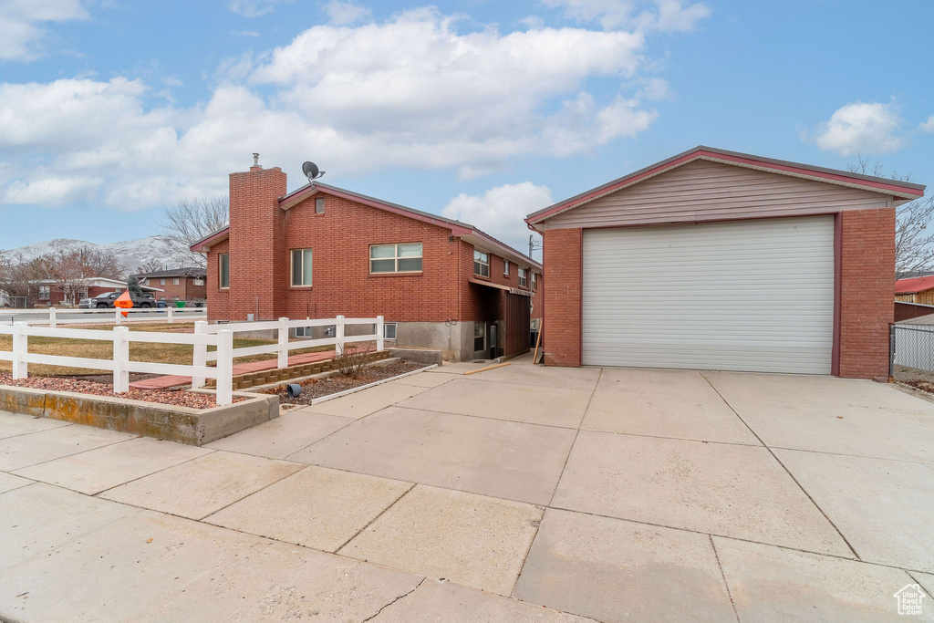 View of side of home featuring a mountain view, a garage, and an outdoor structure