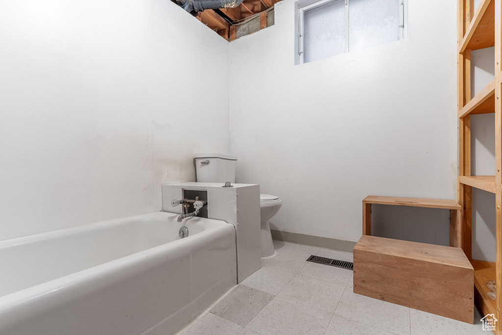 Bathroom featuring a bath and toilet