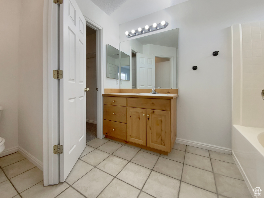 Bathroom with vanity, tile patterned floors, a bathtub, and toilet