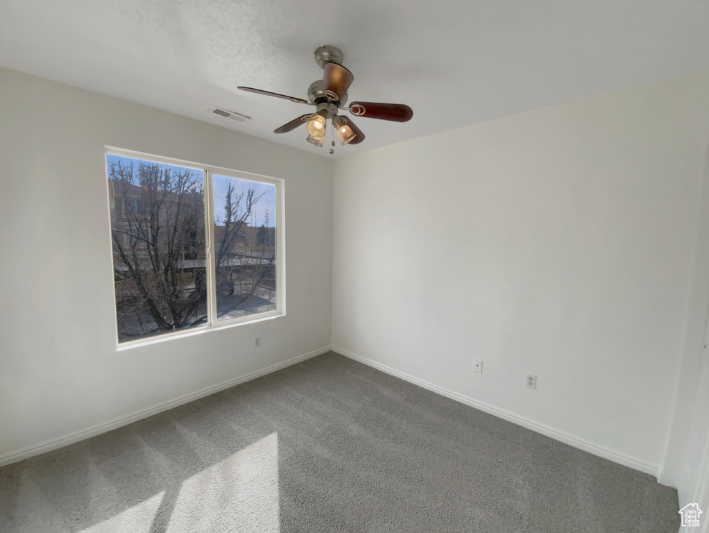 Carpeted spare room with ceiling fan