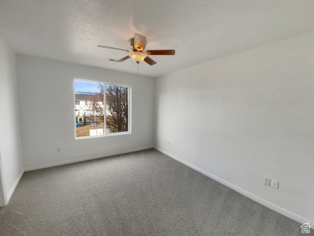 Unfurnished room with ceiling fan, carpet, and a textured ceiling