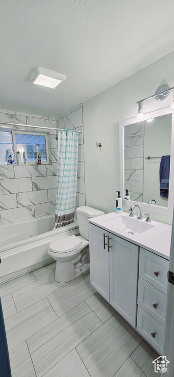 Full bathroom featuring shower / tub combo with curtain, vanity, and toilet