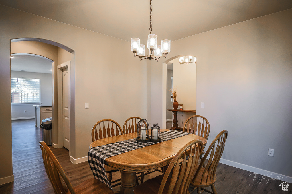 Dining room featuring dark wood-type flooring and an inviting chandelier