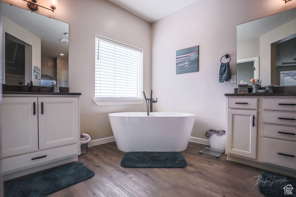 Bathroom with vanity, a tub to relax in, and hardwood / wood-style flooring