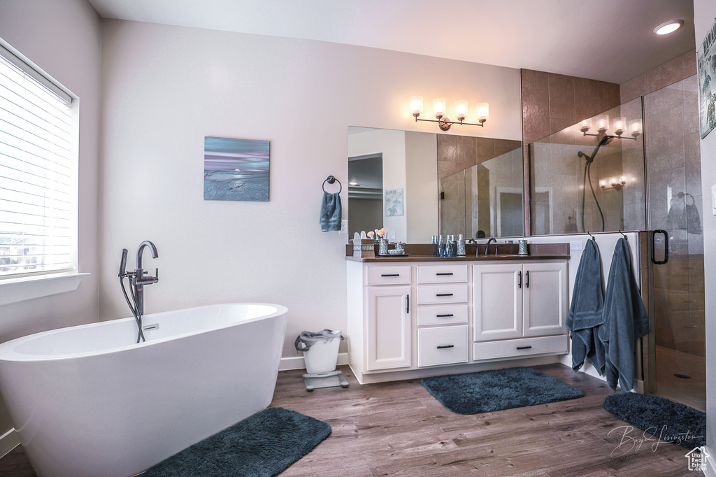 Bathroom featuring vanity, shower with separate bathtub, and hardwood / wood-style floors