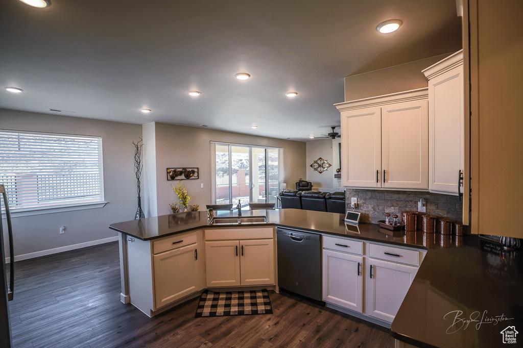 Kitchen featuring black dishwasher, sink, kitchen peninsula, and white cabinets