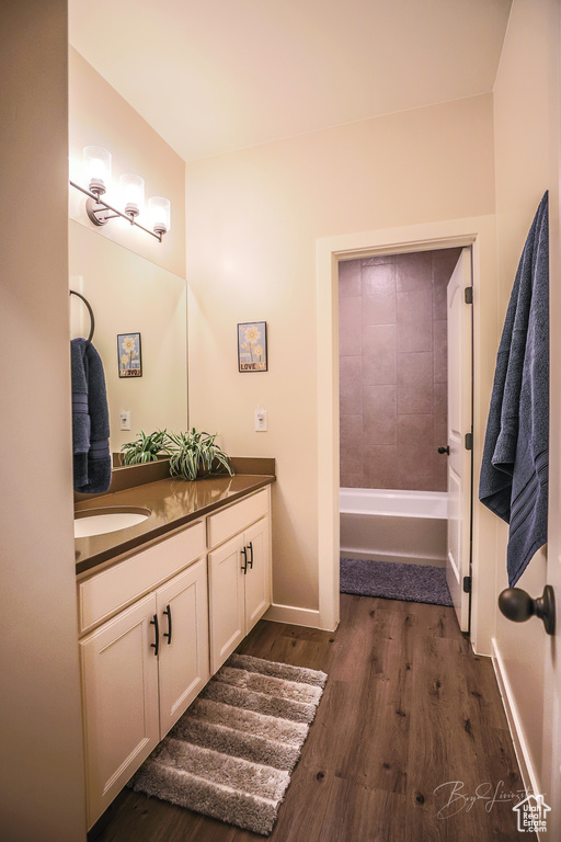 Bathroom featuring vanity, hardwood / wood-style floors, and a washtub